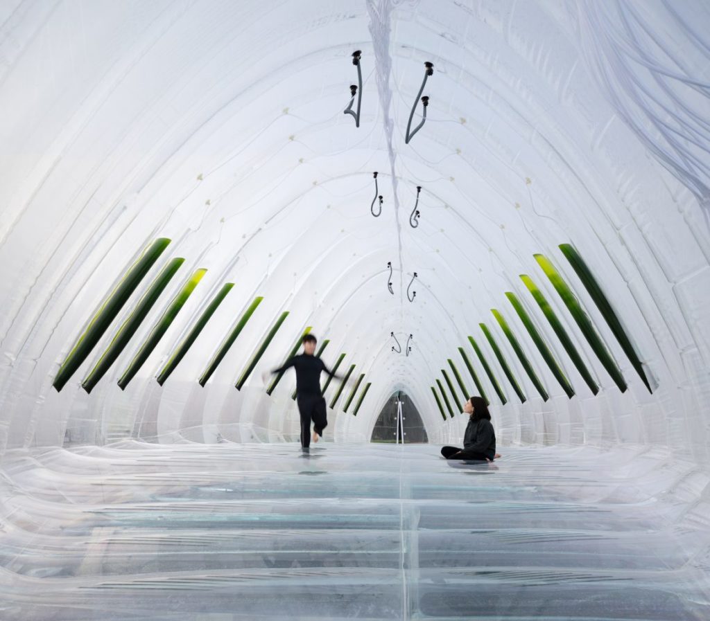 A kid plays inside AirBubble while a woman watches