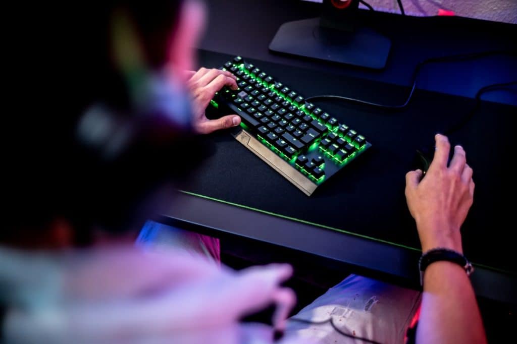 Gamer holds mouse and keyboard as they play video games