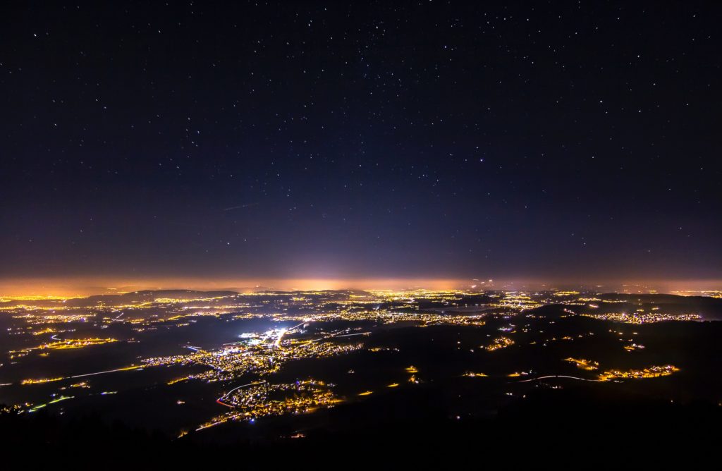 Aerial view of a city at night highlights light pollution