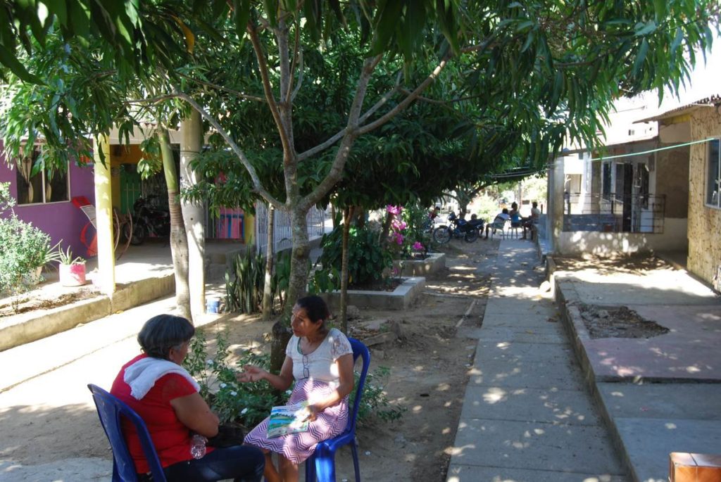 Women sit and chat in the shade in the streets of CM